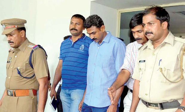 Fire authority supervisor Aji Kumar (extreme right), prime accused in the Karipur airport is escorted by Police. (Photo: PTI) Fire authority supervisor Aji Kumar (extreme right), prime accused in the Karipur airport is escorted by Police. (Photo: PTI)